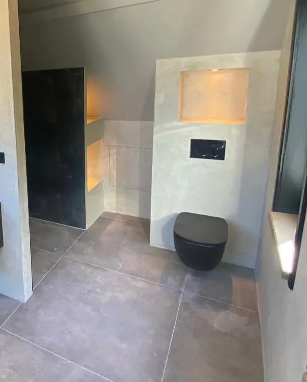 Zwart hangtoilet met inbouwreservoir en verlichte nis
