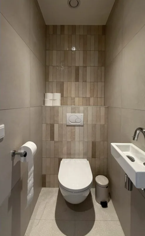 Toilet renovatie in Amsterdam met hangtoilet, staande wandtegels en fontein