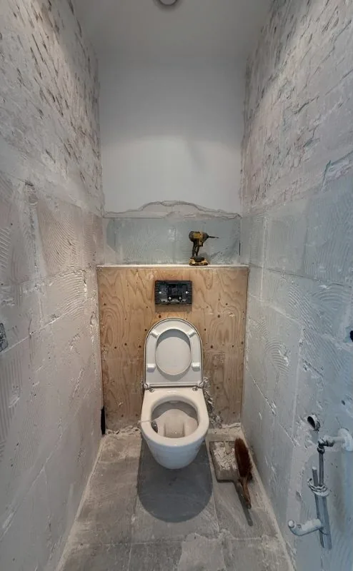 Toiletruimte tijdens de sloop met zichtbare leidingen